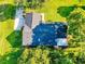 An aerial view of a residential home featuring a pristine roof and lush, verdant landscaping at 7787 Nw 56Th Pl, Ocala, FL 34482