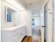 Bright bathroom features a white vanity with marble countertop and wood-look flooring at 7787 Nw 56Th Pl, Ocala, FL 34482