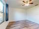 Bedroom showcasing laminate flooring, ceiling fan, and window with black-out curtains at 7787 Nw 56Th Pl, Ocala, FL 34482