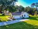 Charming house with a well-manicured lawn, a paved driveway, and lush trees, great curb appeal at 7787 Nw 56Th Pl, Ocala, FL 34482