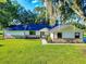 Attractive single-story home with a well-maintained lawn, brick accents, and beautiful landscaping at 7787 Nw 56Th Pl, Ocala, FL 34482