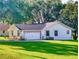 A charming single-story home with a spacious garage, fresh landscaping, and a vibrant green lawn at 7787 Nw 56Th Pl, Ocala, FL 34482