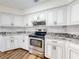 Bright kitchen featuring stainless steel oven, granite countertops, and white cabinets at 7787 Nw 56Th Pl, Ocala, FL 34482