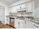 Bright kitchen featuring stainless steel appliances and granite countertops with white cabinetry at 7787 Nw 56Th Pl, Ocala, FL 34482