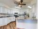 Stylish kitchen with stainless steel appliances, white cabinets, granite countertops, and ceiling fan at 7787 Nw 56Th Pl, Ocala, FL 34482