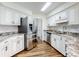 Kitchen with stainless steel fridge and dishwasher, granite countertops and white cabinets at 7787 Nw 56Th Pl, Ocala, FL 34482