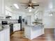 Modern kitchen with stainless appliances, white cabinets, granite countertops, and wood floors at 7787 Nw 56Th Pl, Ocala, FL 34482