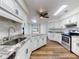Open kitchen with white cabinets, granite countertops, stainless steel appliances, skylights and wood floor at 7787 Nw 56Th Pl, Ocala, FL 34482