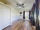 Sunroom boasts wood floors, a ceiling fan, closet, and large windows with dark curtains at 7787 Nw 56Th Pl, Ocala, FL 34482