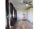 Sunroom with wood flooring, large windows with dark curtains leads into kitchen at 7787 Nw 56Th Pl, Ocala, FL 34482