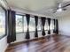 Sunroom with wood flooring and large windows with dark curtains for a bright interior at 7787 Nw 56Th Pl, Ocala, FL 34482