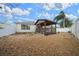 Backyard gazebo with rock landscaping, white fencing, and a partial view of the house at 882 Tanglewood Pl, The Villages, FL 32162