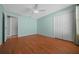 Light blue bedroom with hardwood floors and closet doors; bright and airy at 882 Tanglewood Pl, The Villages, FL 32162