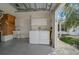 Garage features laundry area with white washer and dryer and additional storage cabinets at 882 Tanglewood Pl, The Villages, FL 32162
