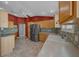 Bright kitchen with light wood cabinets, stainless steel refrigerator, and tile backsplash at 882 Tanglewood Pl, The Villages, FL 32162
