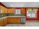 Charming kitchen featuring light wood cabinets, tiled backsplash, and stainless steel dishwasher at 882 Tanglewood Pl, The Villages, FL 32162