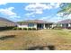 Backyard featuring a screened-in porch, landscaping, and expansive lawn at 9728 Sw 95Th Loop, Ocala, FL 34481