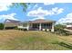 A screened-in porch enhances this home's back exterior, complemented by manicured landscaping at 9728 Sw 95Th Loop, Ocala, FL 34481