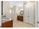 Spacious bathroom with dual vanities, granite countertops, and tile flooring at 9728 Sw 95Th Loop, Ocala, FL 34481