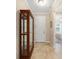Tiled foyer featuring a glass display cabinet and views of a bedroom, creating a bright entrance at 9728 Sw 95Th Loop, Ocala, FL 34481