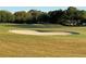 Scenic golf course view featuring lush green grass and challenging sand traps at 16751 Se 84Th Colerain Cir, The Villages, FL 32162