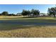 View of a beautiful golf course with lush green grass and a paved path at 16751 Se 84Th Colerain Cir, The Villages, FL 32162
