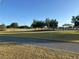 View of a beautiful golf course with lush green grass and a paved path at 16751 Se 84Th Colerain Cir, The Villages, FL 32162
