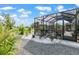A screened-in patio with gravel, palm trees and a table and chairs at 10293 Sw 96Th Ln, Ocala, FL 34481