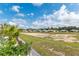 Landscaped backyard with gravel, palm trees and a grassy field in the distance at 10293 Sw 96Th Ln, Ocala, FL 34481