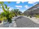 A screened-in patio with a gravel path, palm trees and white rock beds at 10293 Sw 96Th Ln, Ocala, FL 34481