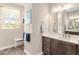 Bright bathroom features a modern vanity, a large mirror, and a window that lets in natural light for a spa-like experience at 10293 Sw 96Th Ln, Ocala, FL 34481