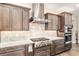 Kitchen featuring a stainless steel range hood, stone countertops, and modern appliances at 10293 Sw 96Th Ln, Ocala, FL 34481