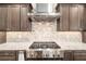 Close-up of a stainless steel range top with modern cabinetry and stone countertops at 10293 Sw 96Th Ln, Ocala, FL 34481