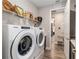 Laundry room with appliances, overhead shelving, and light wood-look flooring at 10293 Sw 96Th Ln, Ocala, FL 34481