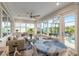 Sunroom with bright windows, tile floor, ceiling fan, sofa, and dining table with seating at 10293 Sw 96Th Ln, Ocala, FL 34481