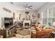 Comfortable living room with fireplace, eclectic decor, and ample natural light at 10293 Sw 96Th Ln, Ocala, FL 34481