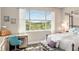 Bright bedroom is complemented by natural light, a comfy bench and an eye-catching view of the verdant landscaping at 10293 Sw 96Th Ln, Ocala, FL 34481