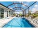 Stunning screened pool with waterfall feature, lounge chairs, and ample seating area for relaxation and entertainment at 10293 Sw 96Th Ln, Ocala, FL 34481