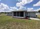 Backyard features screened in porch and concrete patio, with lush green grass at 10315 Sw 62Nd Terrace Rd, Ocala, FL 34476