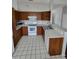 Traditional kitchen features wood cabinetry, tiled floor, and white appliances at 10315 Sw 62Nd Terrace Rd, Ocala, FL 34476