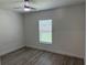 Bright bedroom featuring sleek floors, ceiling fan, and a window providing natural light at 11165 Nw 7Th St, Ocala, FL 34482
