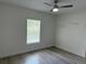 Bright bedroom with ceiling fan, wood-look floors, and a large window at 11165 Nw 7Th St, Ocala, FL 34482