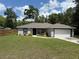 Charming home with a well-manicured lawn, gray exterior, and attached garage at 11165 Nw 7Th St, Ocala, FL 34482