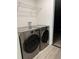 Laundry room with gray front-loading washer and dryer near the garage door at 11165 Nw 7Th St, Ocala, FL 34482