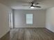 Neutral living space with a modern ceiling fan, sleek floors, and natural light from the window at 11165 Nw 7Th St, Ocala, FL 34482