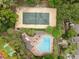 Aerial shot of a community pool and tennis court surrounded by trees at 113 Weeping Elm Ln, Longwood, FL 32779