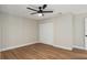 This bedroom features wood floors, vertically paneled walls, and a ceiling fan with a light at 113 Weeping Elm Ln, Longwood, FL 32779
