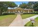 Exterior of the community clubhouse showcasing a covered front porch, manicured lawn, and landscaping at 113 Weeping Elm Ln, Longwood, FL 32779