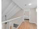 Upstairs hallway with wood floors, white railings, and view into bedroom at 113 Weeping Elm Ln, Longwood, FL 32779