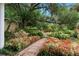 A garden landscape featuring colorful flowers, lush plants, and a brick walkway at 113 Weeping Elm Ln, Longwood, FL 32779